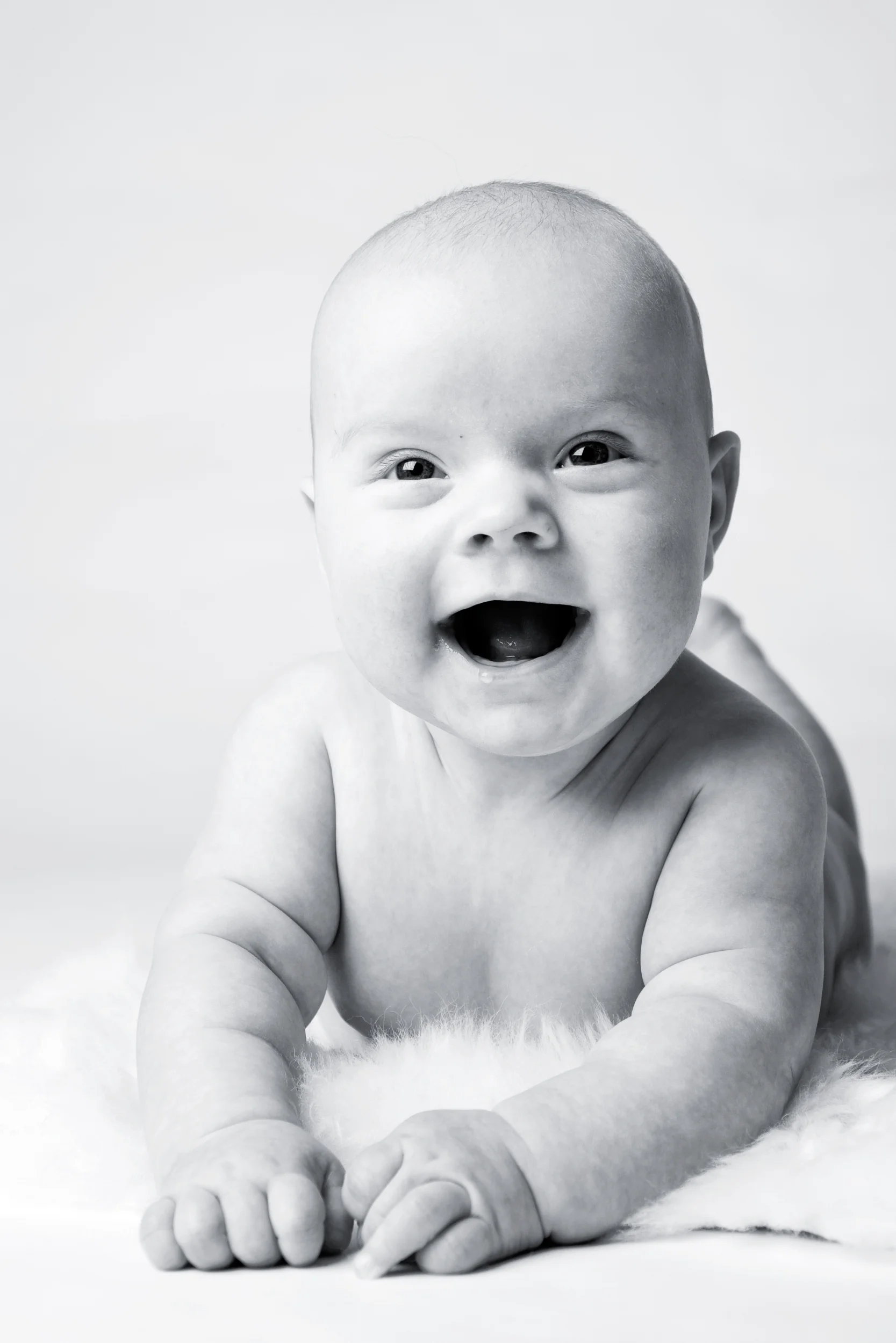 Strålende baby smil i sort/hvid fotografering