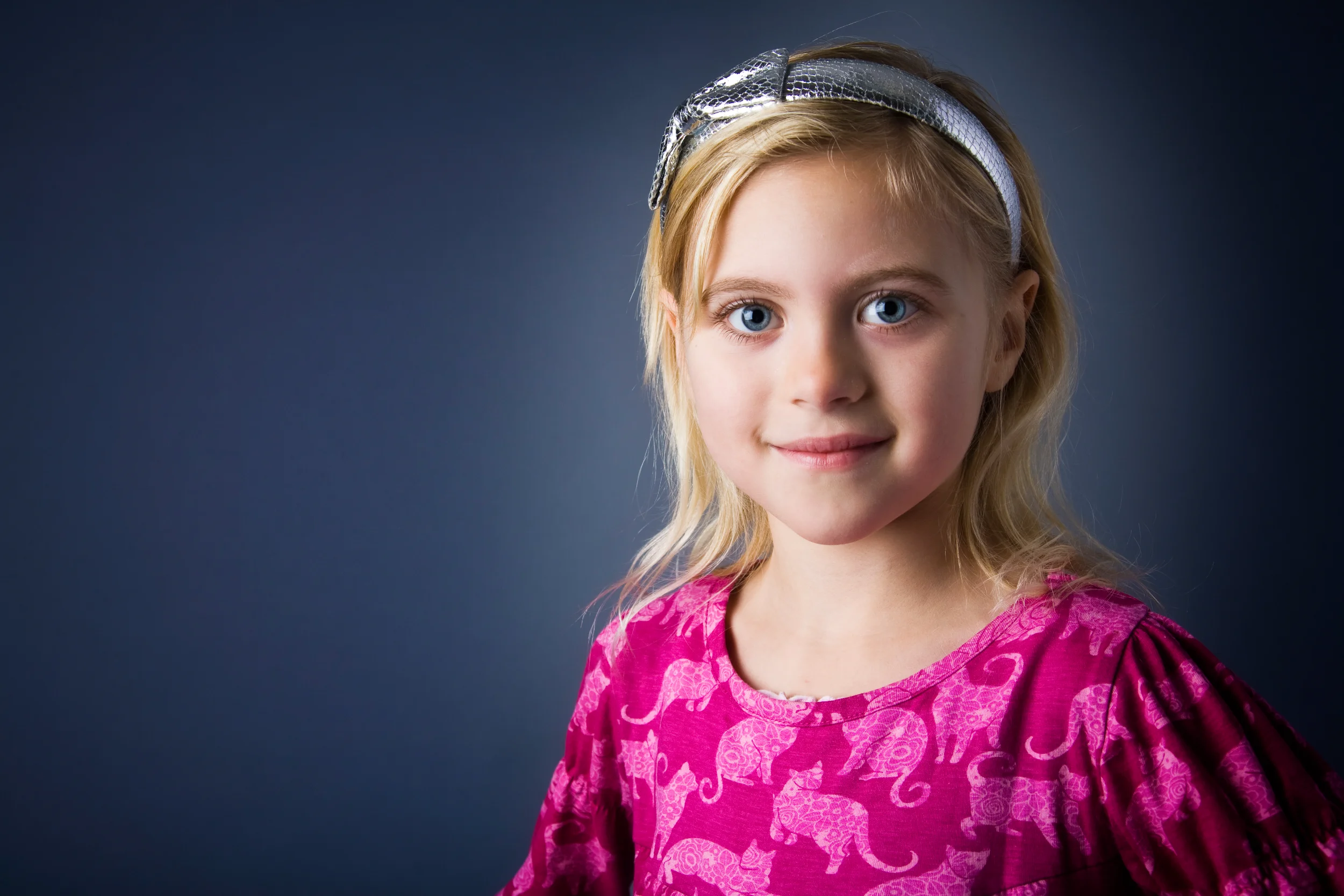 Studieportræt af barn – smilende pige med hårbøjle