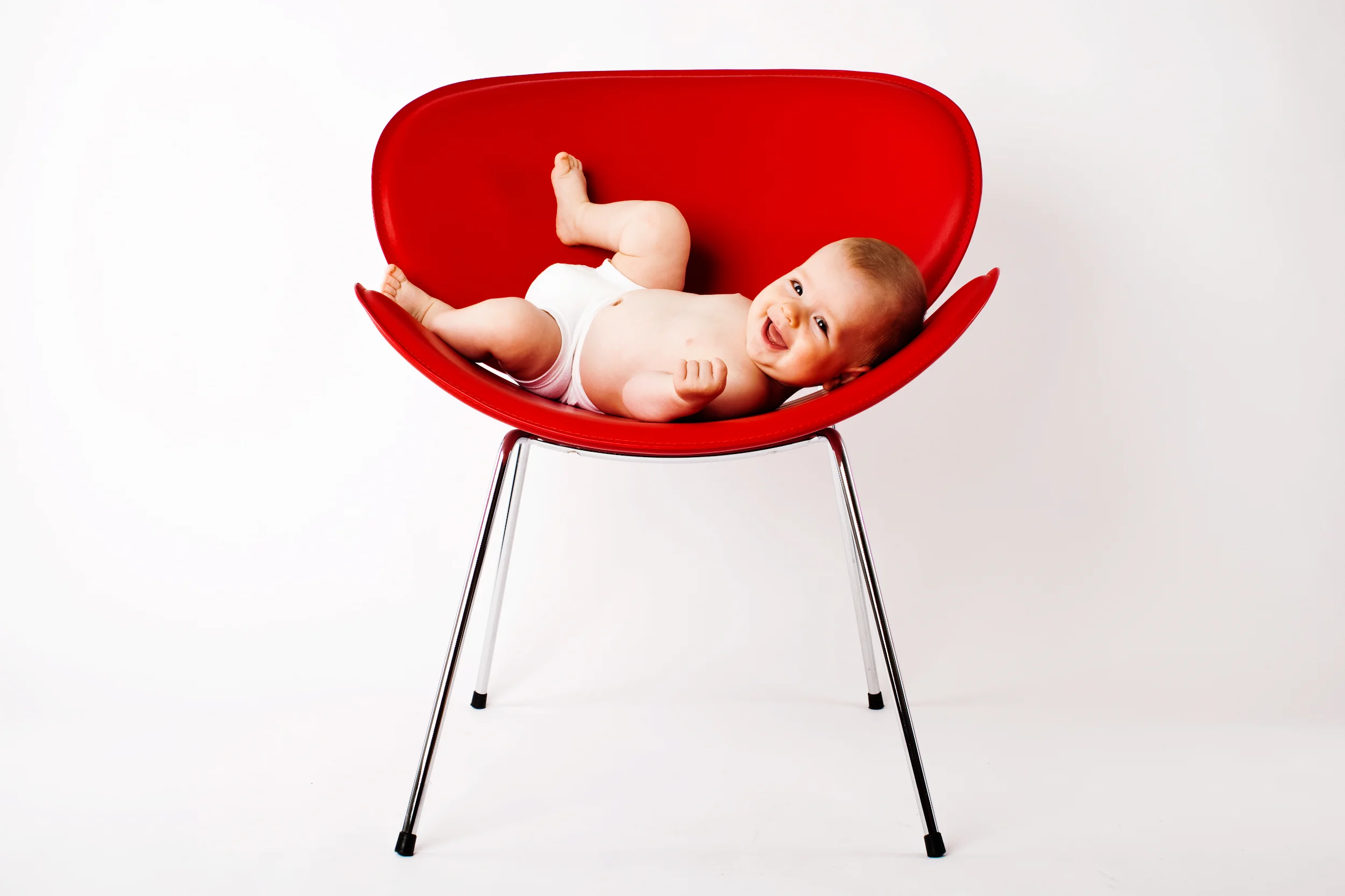 Legesyg baby med glæde i rød stol