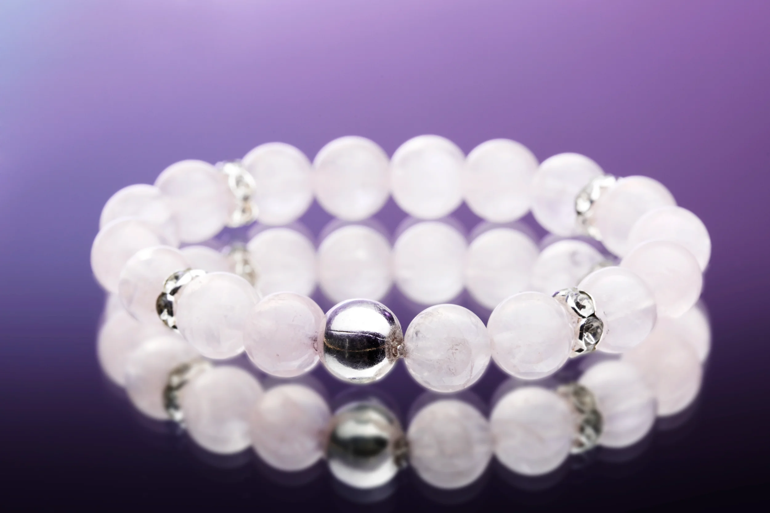 Elegant armbånd med lyserøde perler og sølvdetaljer