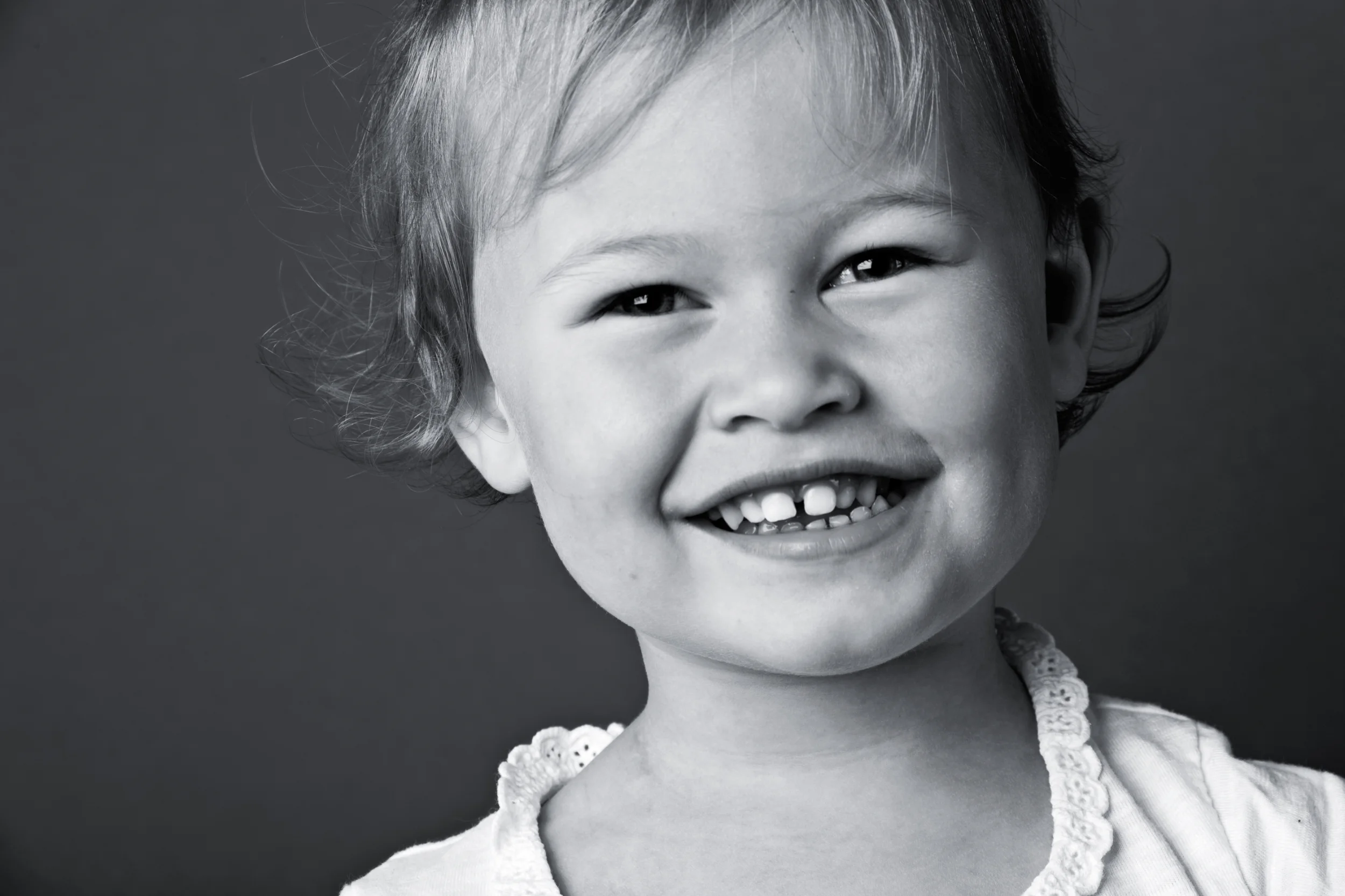 Legende smil fra et barn i sort/hvid fotografering