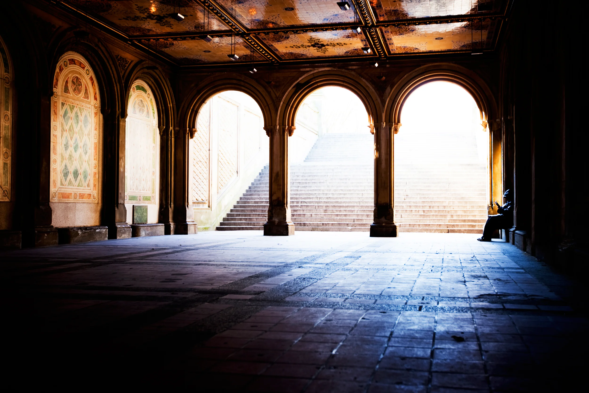 Hvælvinger med trappe og siddende person i naturligt lys
