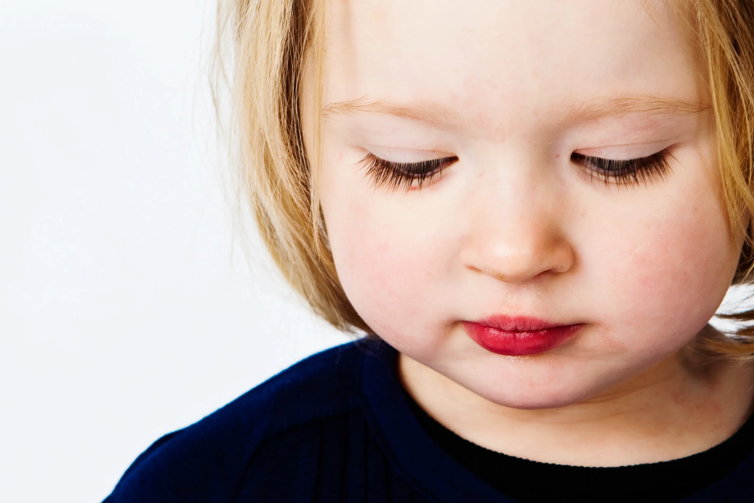 Blondt barn med rød læbestift i et personligt portræt