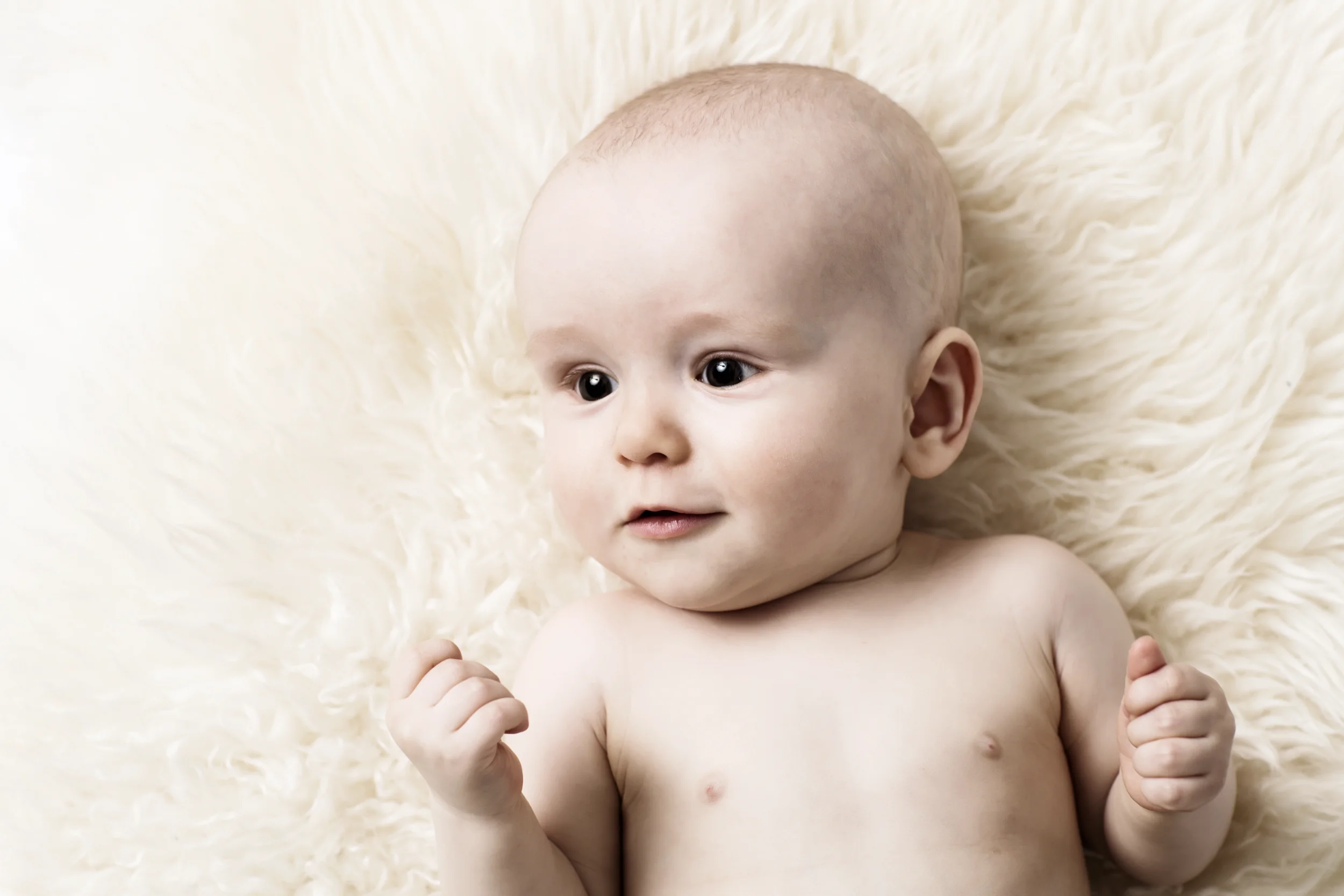 Nysgerrig baby i blødt tæppe – et autentisk babyfotografi