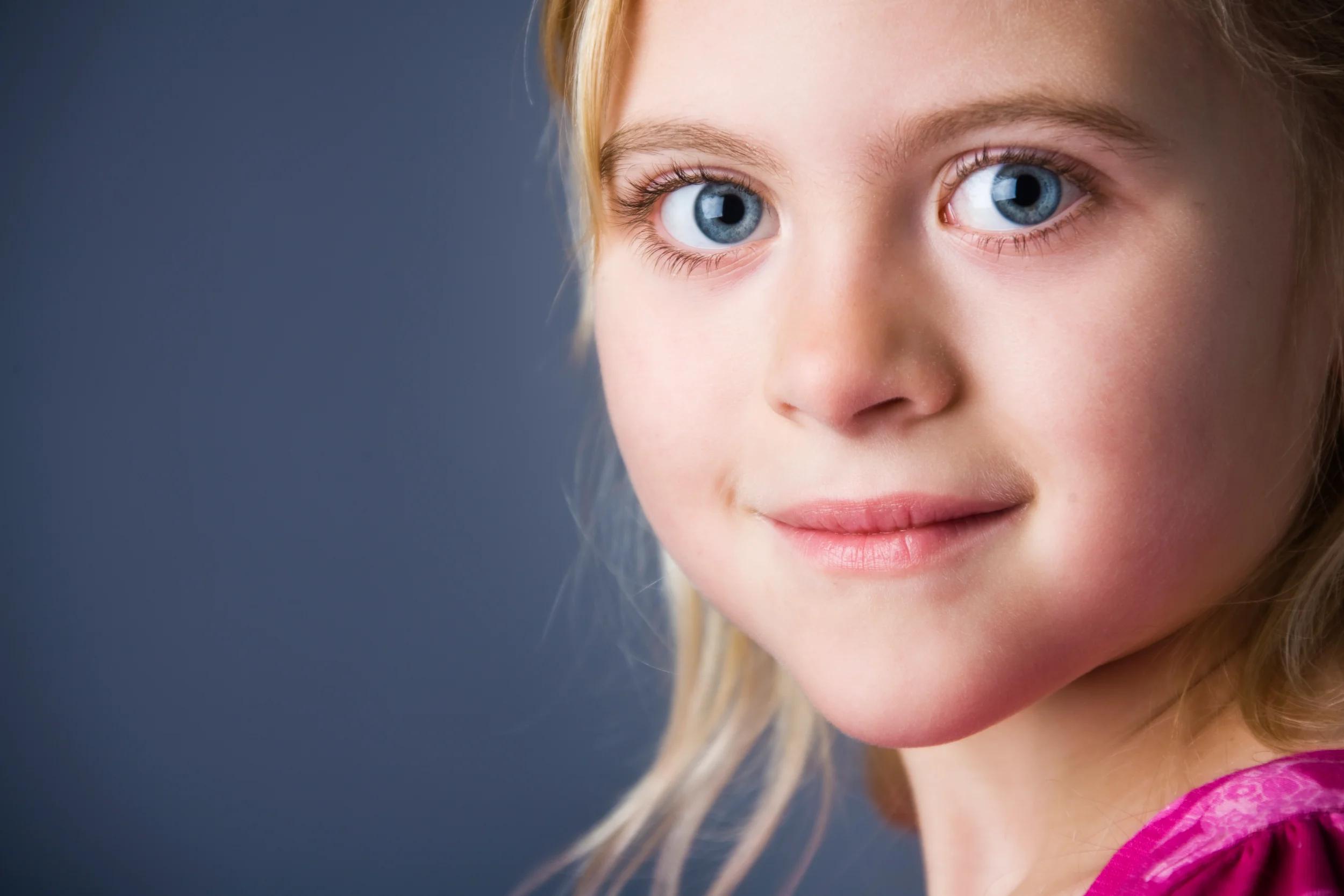 Blå øjne og et spirende smil i et autentisk børneportræt