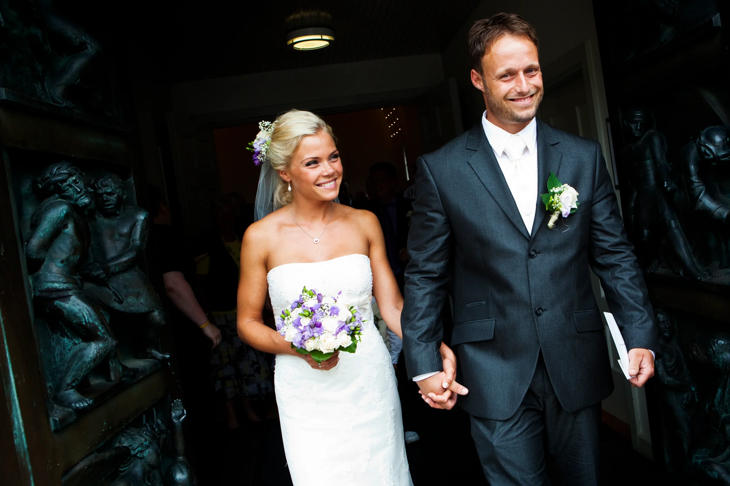 Bryllupspar forlader kirken med et smil