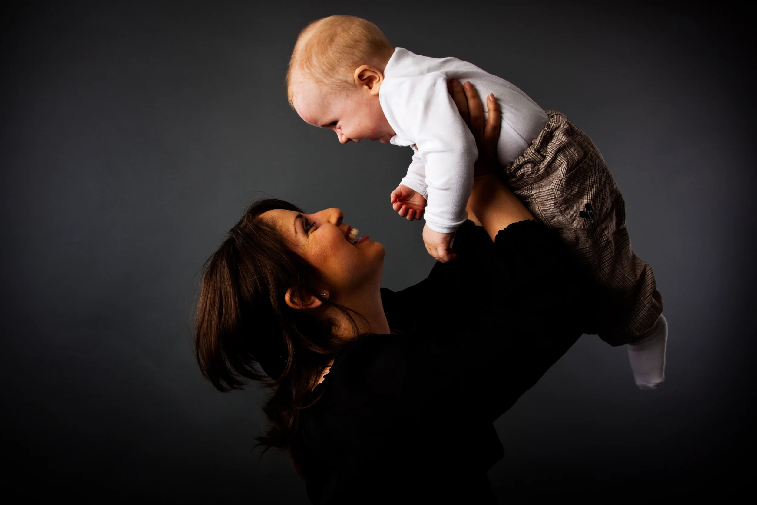 Glad baby og mor i flyvende forelskelse fotografering