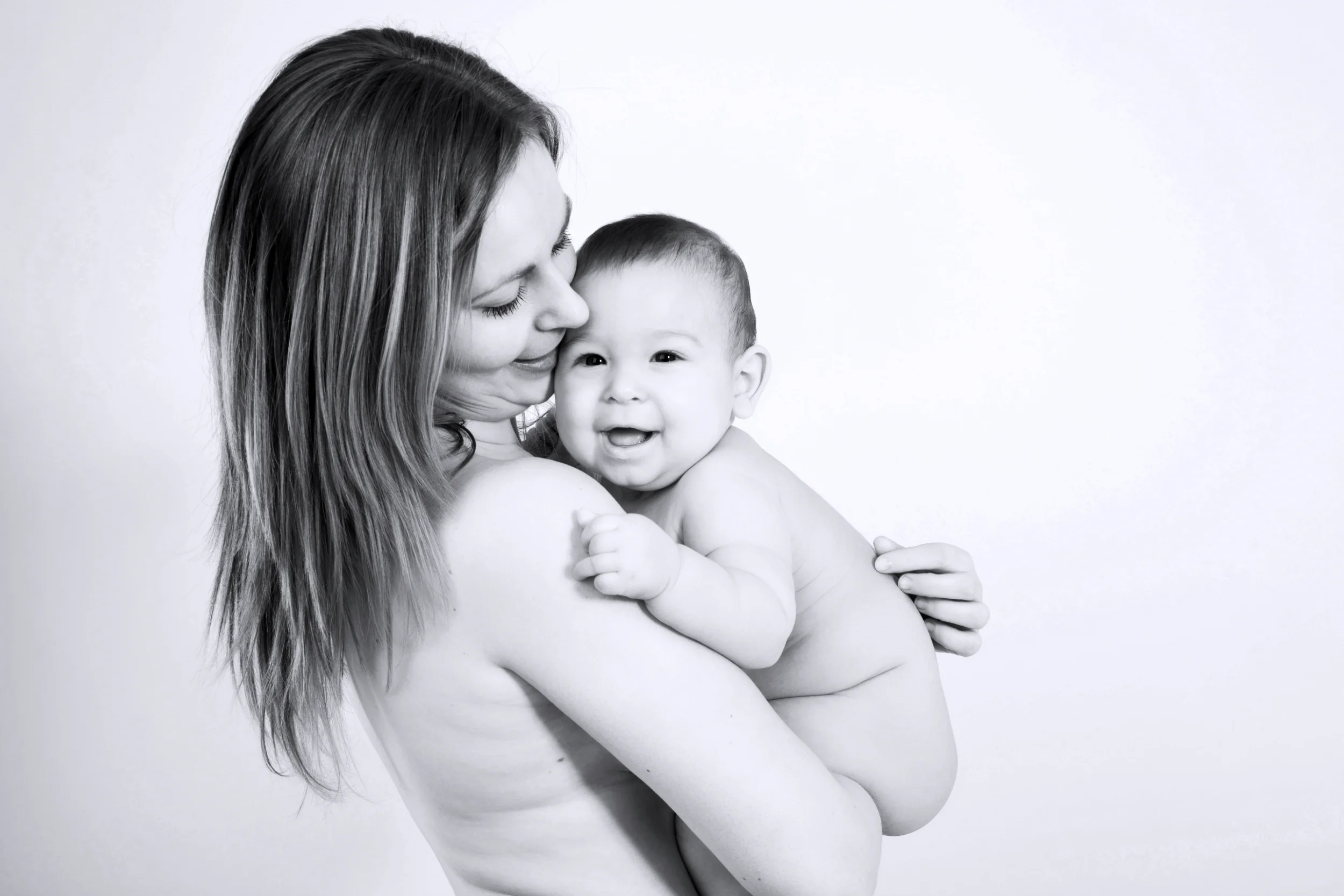 Mor og glad baby omfavner hinanden