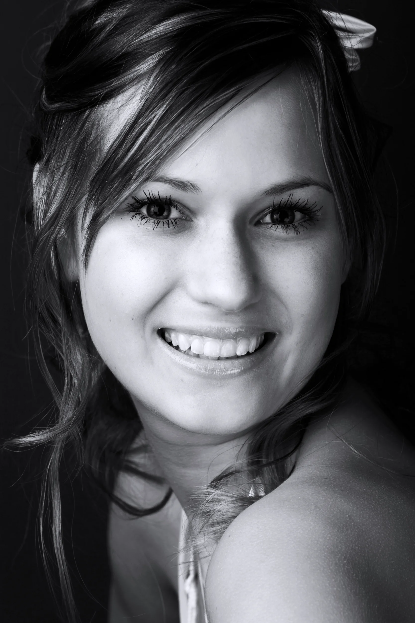 Ung kvinde med ægte smil i sort/hvid portræt