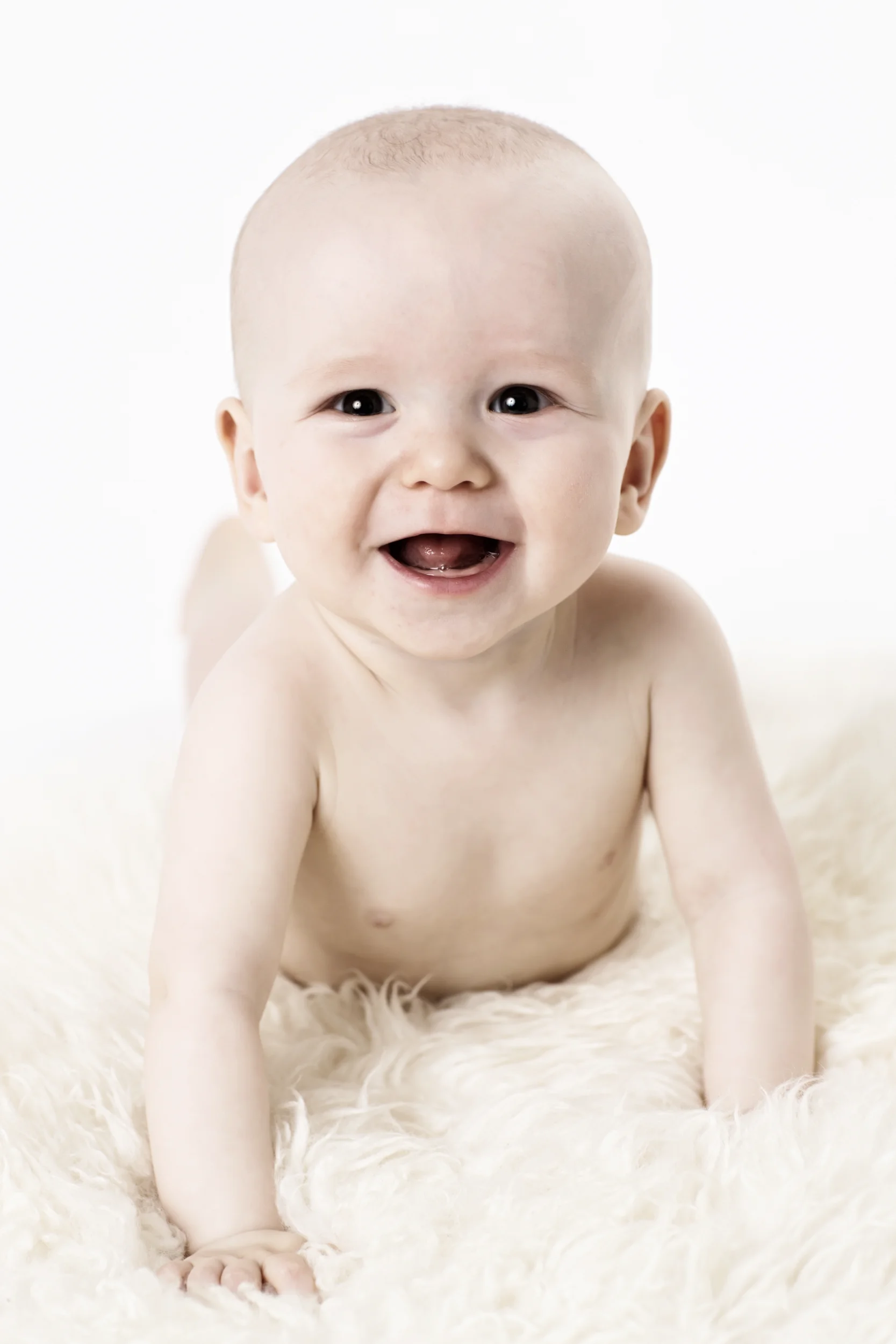 Glad baby med strålende smil i et ægte portrætbillede