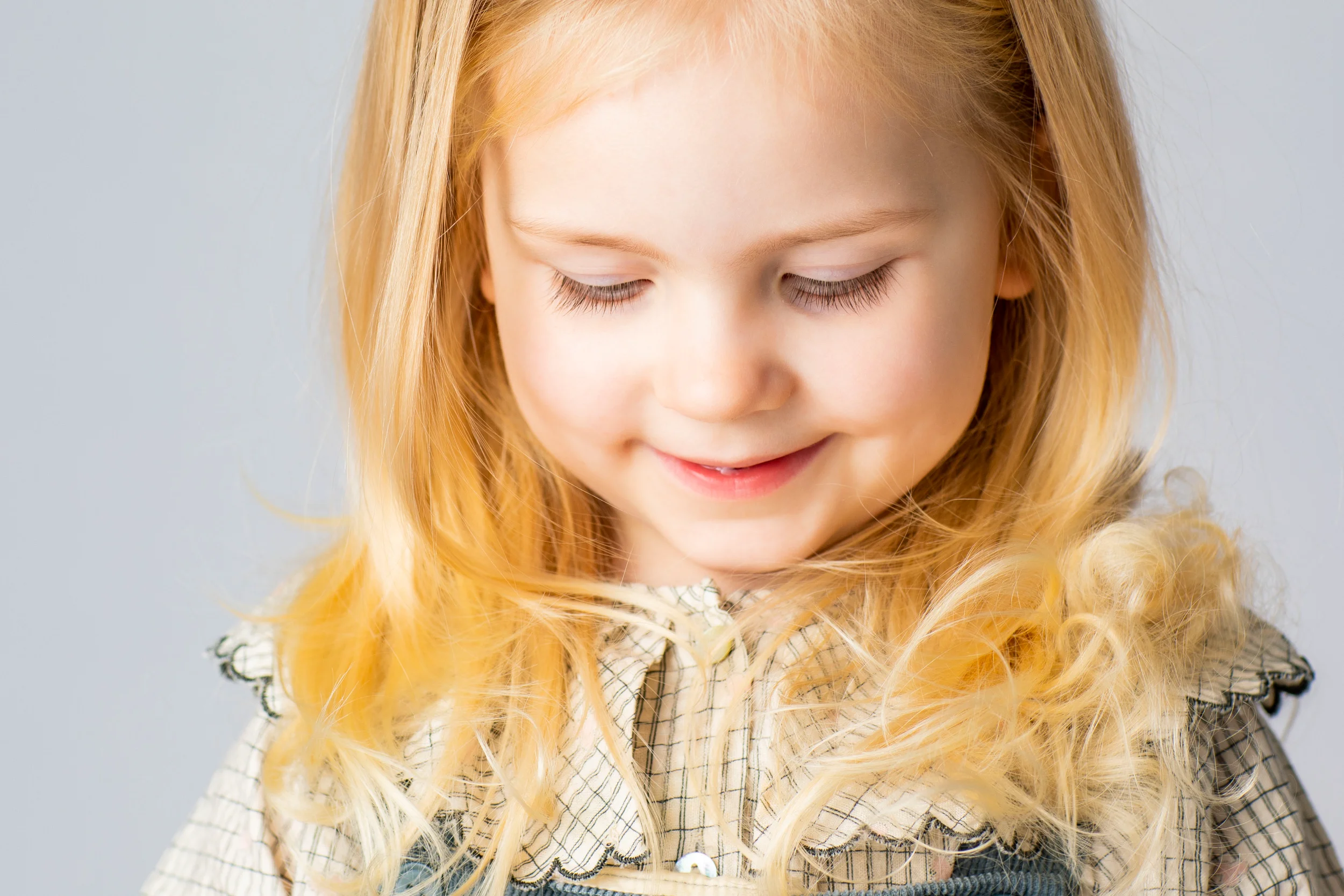 Blondt barn med et autentisk smil til familiebilledet