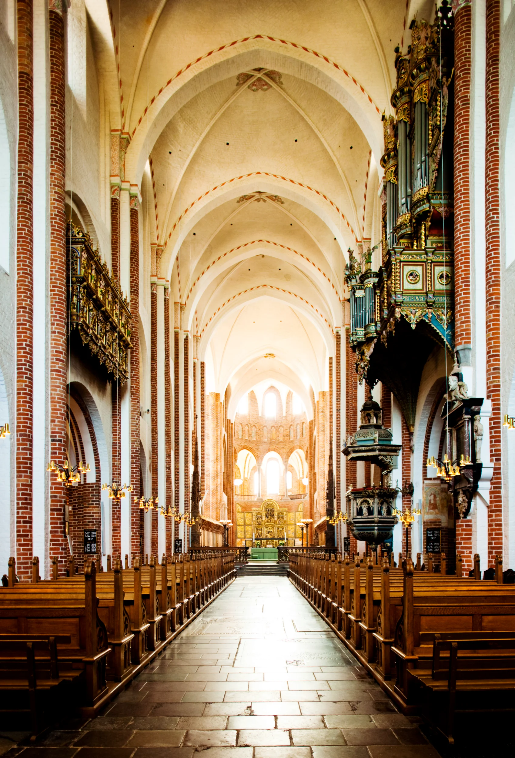 Historisk kirkerum med bænke og gyldags orgel