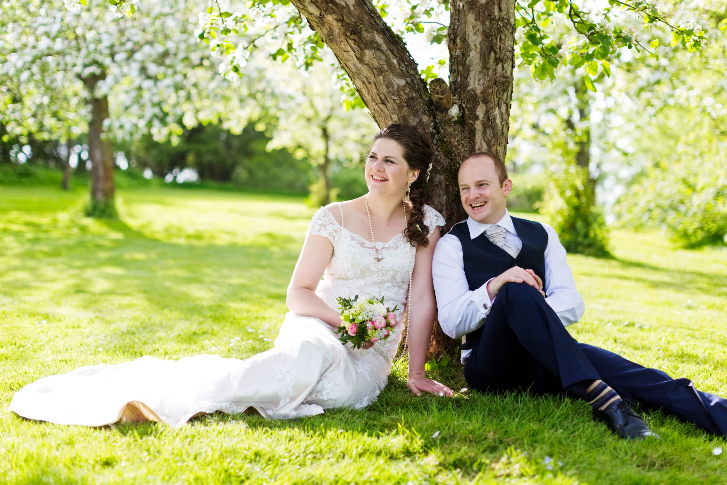 Bryllupspar slapper af under træet i strålende solskin