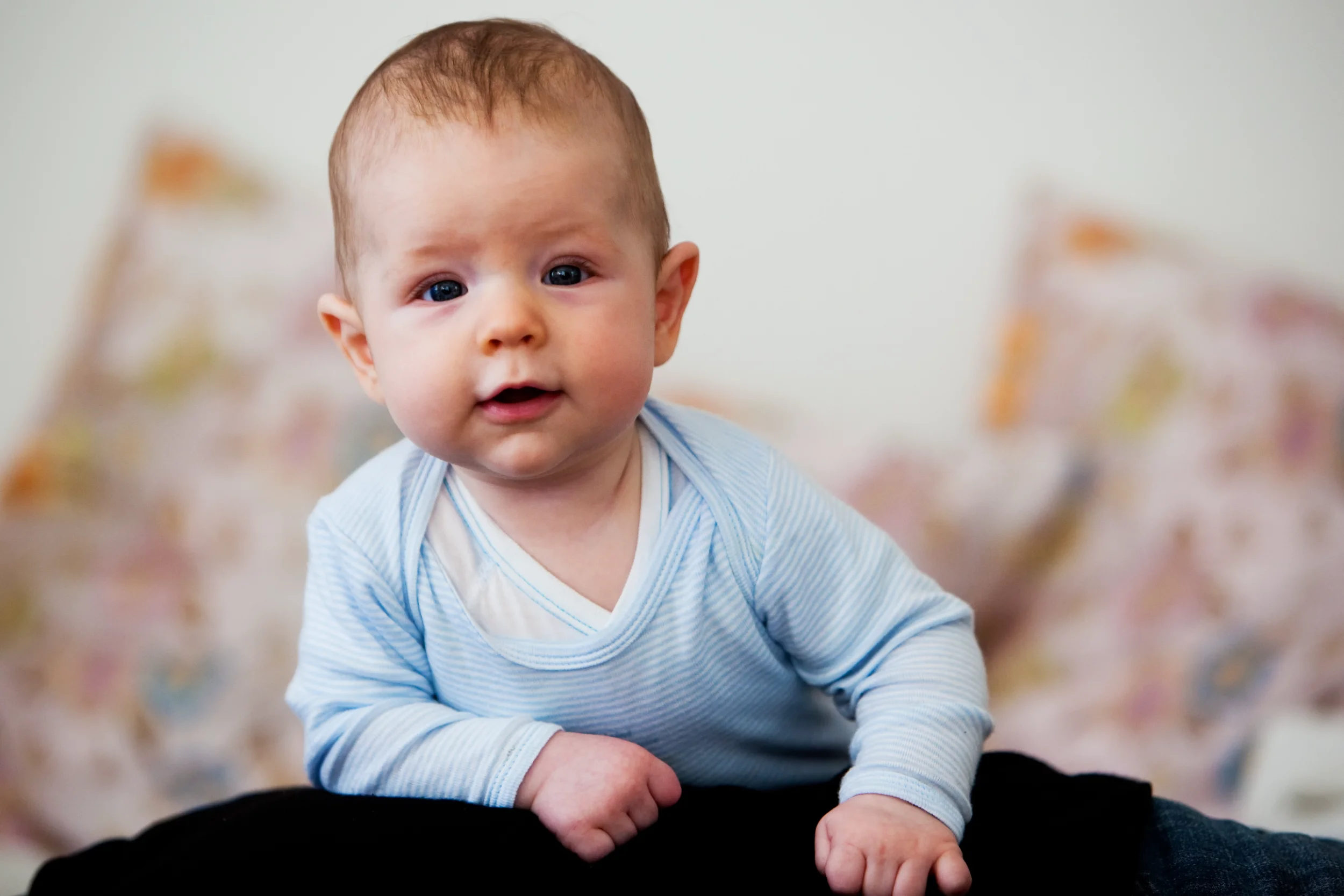 Nysgerrig baby i blåt tøj kigger frem