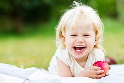 Haven: Smilende barn med æble i leg