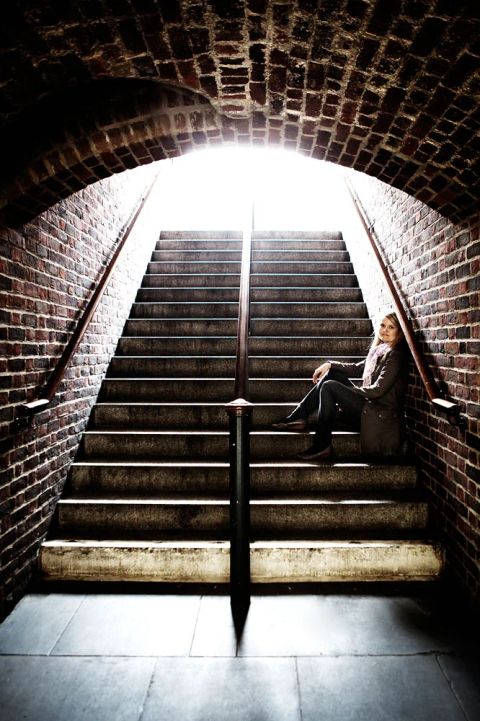 Portræt af kvinde i trappeopgang med naturligt lys