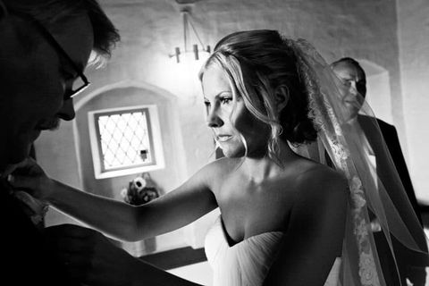 Brudgom gør brud klar til bryllup i kirken