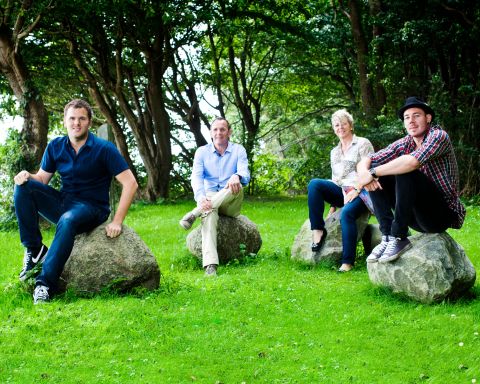 Udendørs familiefoto med naturlige smil i Virum