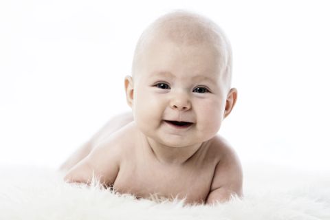 Et ægte baby-smil i blødt lys