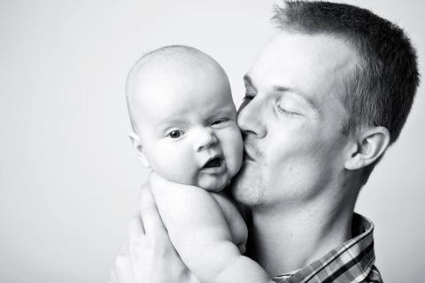 Bløde kinder, ømt kys – et baby fotomfavnelse fotografering