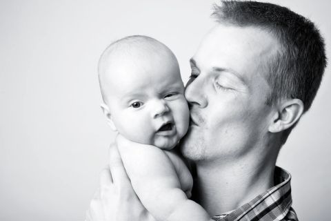 Bløde kinder, ømt kys – et baby fotomfavnelse fotografering