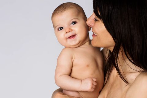 Glad baby med mor, naturlig glæde fotografering