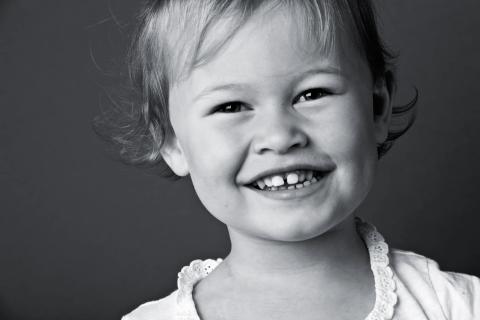 Legende smil fra et barn i sort/hvid fotografering
