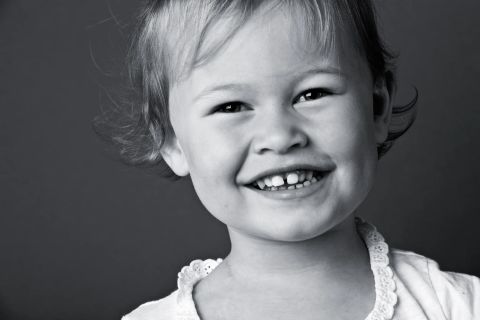 Legende smil fra et barn i sort/hvid fotografering