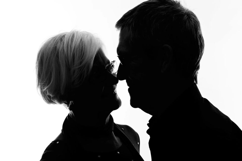 Portrætfoto af to ældre personer i silhuet, ansigt til ansigt i sort/hvid med blødt kantlys.