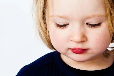 Blondt barn med rød læbestift i et personligt portræt