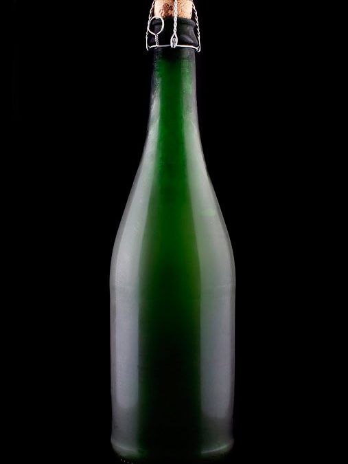 Grøn flaske med korkprop og ståltråd i studiebelysning, klar til servering. Fint et andet foto.