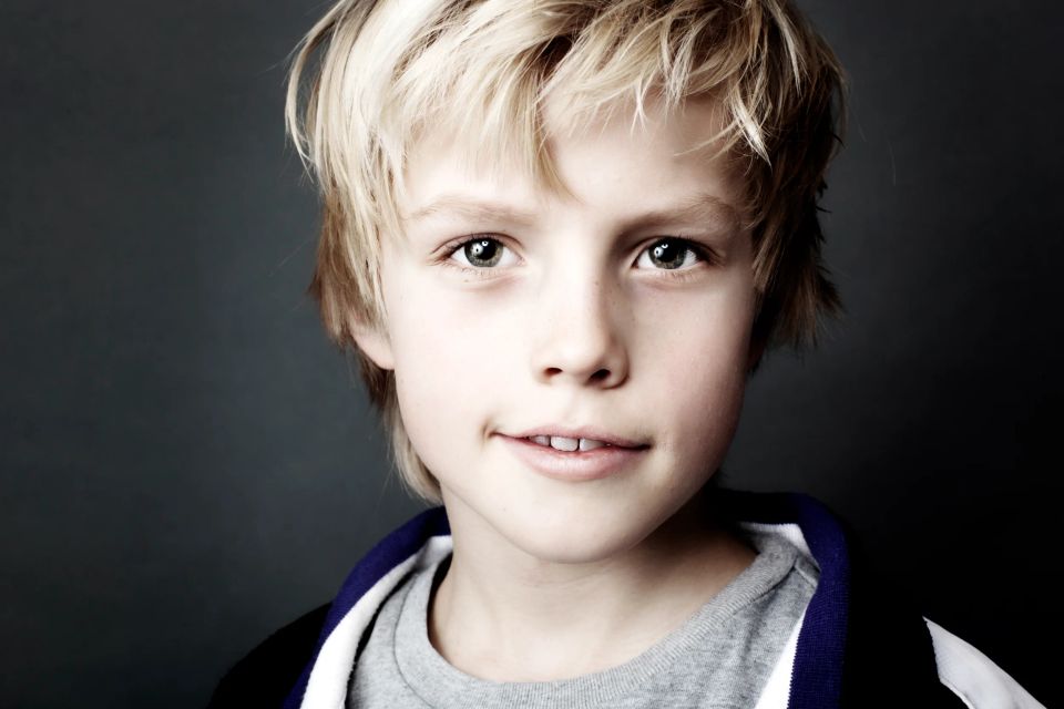 Studieportræt af dreng med intenst blik og lyst hår i blødt lys. Et børnefoto der fanger opmærksomhed med det samme.