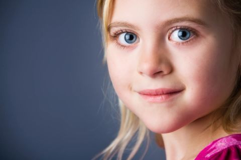 Blå øjne og et spirende smil i et autentisk børneportræt