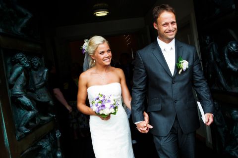 Bryllupspar forlader kirken med et smil