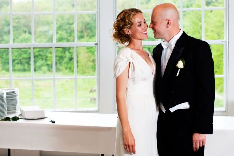 Bryllupspar i naturligt lys foran vindue