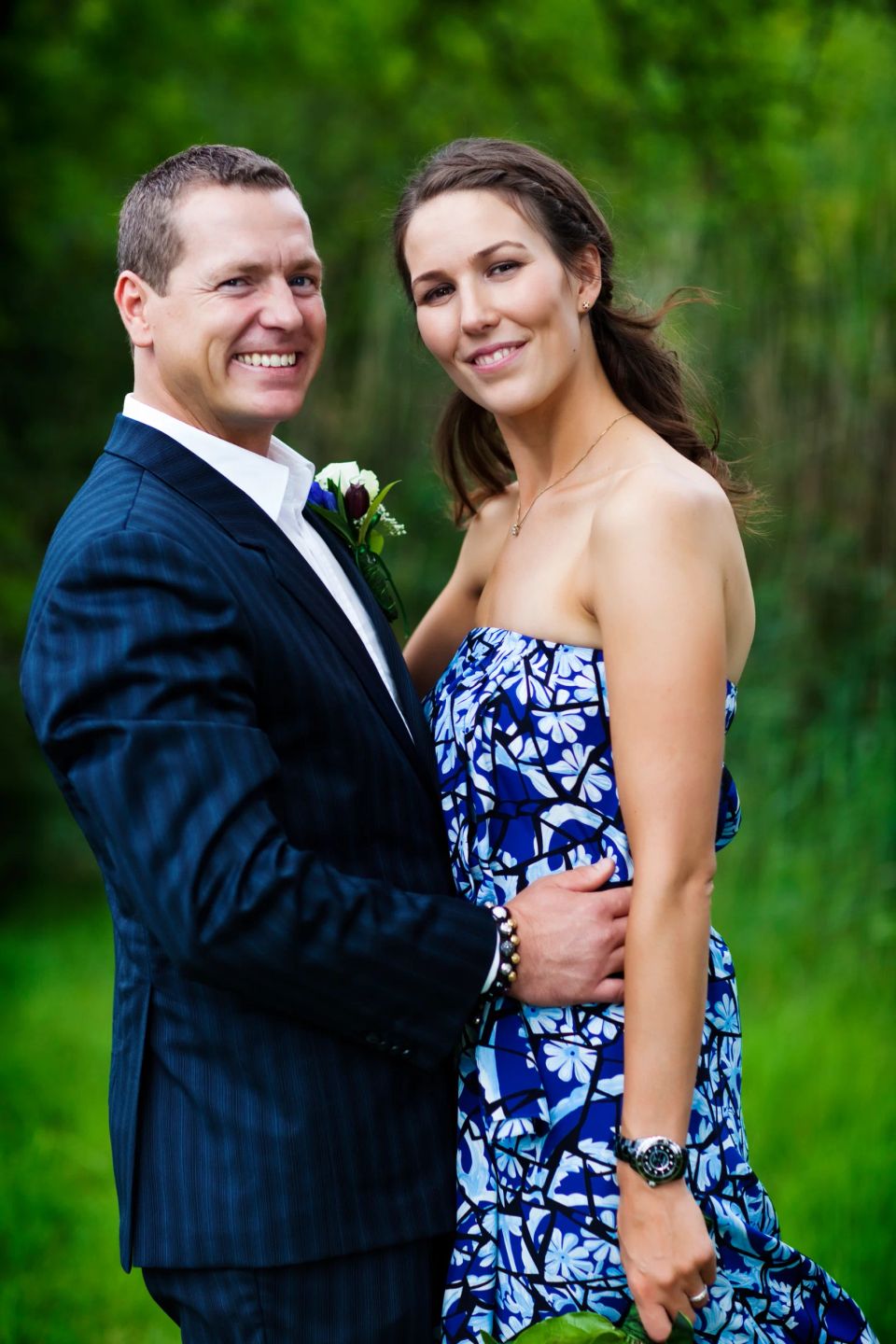 Bryllupsfotografering: Smilende par i Virum. Mand i mørkt jakkesæt, kvinde i blå mønstret kjole. Naturlig stemning.