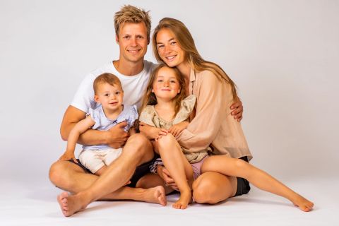Familie sidder smilende sammen i Virum fotostudie
