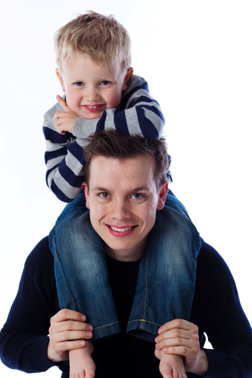 Børn: Far og glad smilende søn på skuldrene mod hvid baggrund i et lyst familiefoto. Virum portræt.