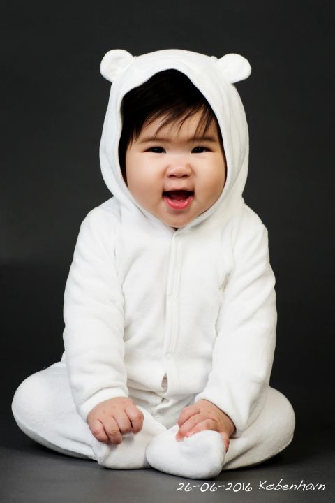 Glad baby i hvid bjørnedragt – et sødt babybillede