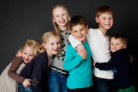 Legende søskende med ægte smil – et autentisk familiebillede