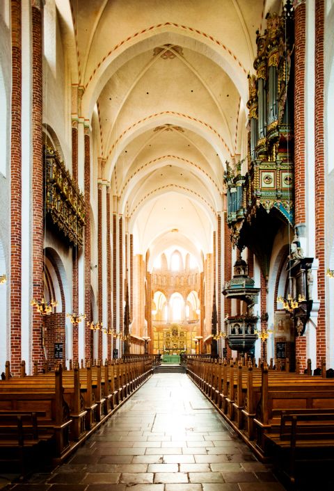 Historisk kirkerum med bænke og gyldags orgel