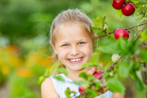 Blå øjne og ægte smil mellem æbletræets grene